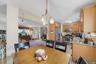 Kitchen and dining area featuring wood cabinetry, granite-style countertops, stainless steel appliances, and a polished wood dining table