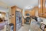 Kitchen featuring light wood cabinetry, stainless steel appliances, granite countertops, and tile flooring