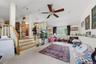 Carpeted living area with a vaulted ceiling, recessed lighting, and a ceiling fan