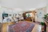 Hardwood-style flooring throughout, an oval-paneled entry door, and a built-in wood-finish cabinet