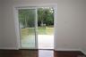 Hardwood-finish flooring, light-toned walls, and a sliding glass door opening to a wooden deck