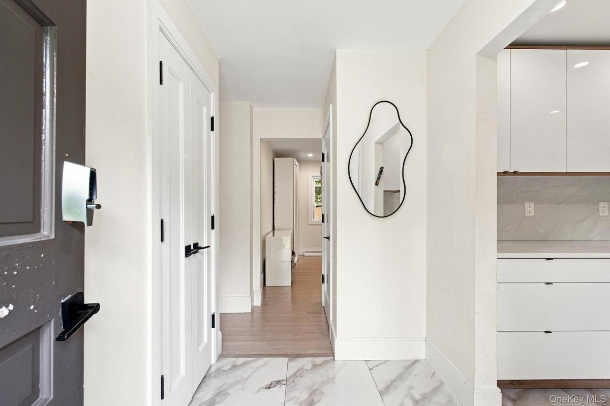 Marble-style tile flooring, white interior doors with black hardware