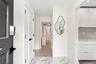 Marble-style tile flooring, white interior doors with black hardware