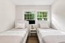 Light-toned walls, wood-finish flooring, and white trim windows