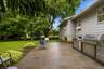 Expansive patio with stone pavers and a built-in outdoor kitchen featuring stainless steel appliances