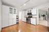 Charming white kitchen with granite countertops, stainless steel appliances, and abundant storage - plenty of room to add a breakfast table for casual