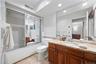 Ensuite primary bathroom with granite-top vanity.
