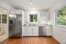 Charming white kitchen with granite countertops, stainless steel appliances, and abundant storage - plenty of room to add a breakfast table for casual