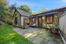 2 exits to a secluded private blue stone patio overlooking lush greenery.