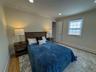 Wood-finish flooring, recessed lighting, crown molding, double-pane window, and a built-in closet