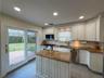 Kitchen featuring white cabinetry, granite countertops, stainless steel appliances, and tile flooring