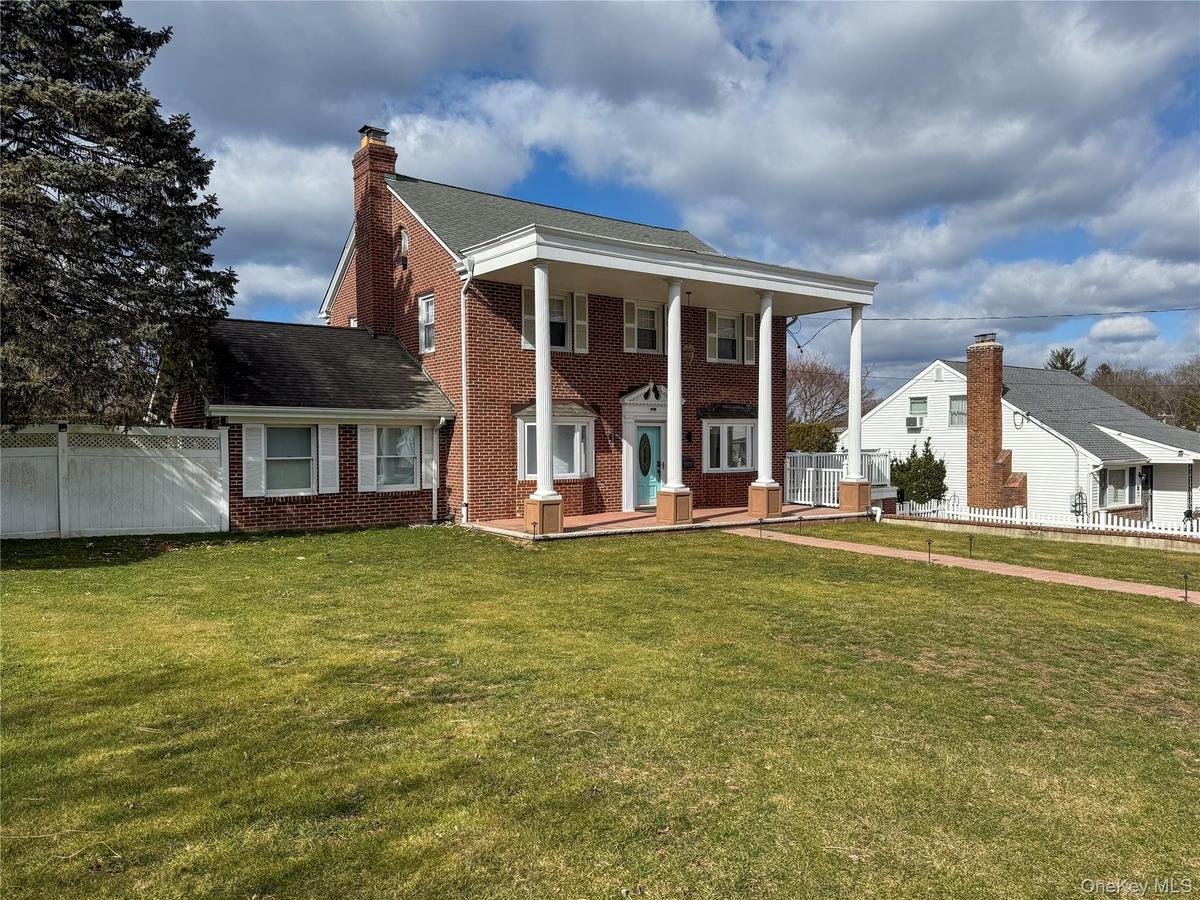 Brick exterior with white columned portico and turquoise entry door