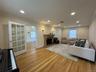 Hardwood flooring, recessed lighting, ornate fireplace with stone surround, crown molding, and French doors