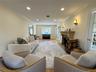 Hardwood flooring, crown molding, recessed lighting, stone fireplace, and double French doors