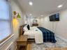 Wood-finish flooring with a decorative area rug, recessed ceiling lighting, and crown molding