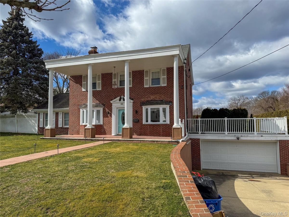 Brick exterior with a prominent portico featuring round columns, 2 car garage