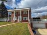 Brick exterior with a prominent portico featuring round columns, 2 car garage