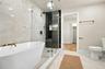 Primary bath with soaking tub, a walk in shower, and leading into walk in closet