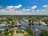 Waterfront property featuring a private boat dock, lush green landscaping, and a circular driveway