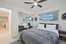 Recessed lighting with a ceiling fan, dual sliding mirror closet doors, and large windows with roller shades