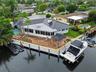 Waterfront property featuring a private boat lift, a dock, and a swimming pool