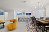 Open-concept living space featuring a modern kitchen with an island, a dining area with a contemporary chandelier, and light-toned flooring throughout