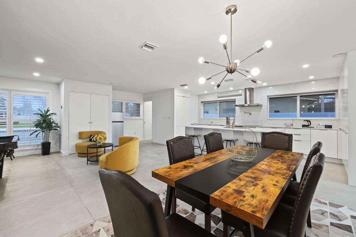 Open-concept living space with recessed lighting and a modern chandelier