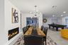 Linear fireplace feature with a light-toned hearth, wood-finish dining table, and a contemporary sputnik chandelier