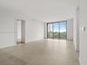 Bright open living and dining area with floor-to-ceiling impact glass