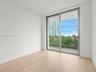 Bright secondary bedroom with floor-to-ceiling window