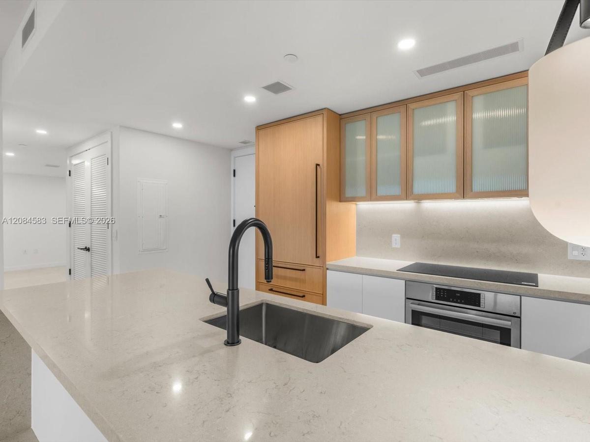 Modern kitchen with wood cabinetry and stone countertops