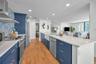 Cucina Features Versay Grand Blue Encaustic Style Porcelain Tile Backsplash, Stainless appliances, Quartz Counter Surfaces, Custom Shaker Style Cabine