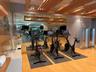 Fitness center featuring wood-finish flooring, mirrored walls, and exposed wood ceiling beams