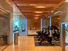 Fitness room featuring wood-finish flooring, a wood-slat ceiling with recessed lighting, mirrored wall panels, and a built-in credenza