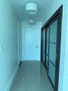 Hallway featuring light-toned tile flooring, white walls, and contemporary drum-shade light fixtures