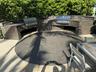 Outdoor kitchen with two built-in stainless steel grills, a sink, and integrated countertop lighting