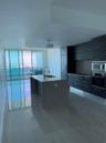 Contemporary kitchen featuring a speckled stone island with an undermount sink and gooseneck faucet