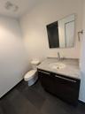 Bathroom featuring a dark wood-finish vanity with a light stone countertop, an undermount sink, and a chrome faucet