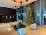 Spacious lobby featuring polished stone flooring, a contemporary chandelier, and a recessed ceiling design