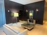 Dark wood-paneled walls with integrated doorways, light-toned flooring, and wall-mounted sconces