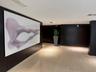 Polished tile flooring with dark wood-paneled walls and a large illuminated art panel