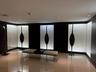 High-gloss tile flooring with recessed ceiling lighting, illuminating a corridor with dark wall panels and backlit display niches