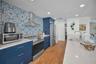 Cucina Features Versay Grand Blue Encaustic Style Porcelain Tile Backsplash, Stainless appliances, Quartz Counter Surfaces, Custom Shaker Style Cabine
