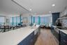 Cucina Features Versay Grand Blue Encaustic Style Porcelain Tile Backsplash, Stainless appliances, Quartz Counter Surfaces, Custom Shaker Style Cabine