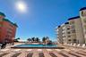 RESORT-STYLE POOL DECK COMPLETE WITH LOUNGE CHAIRS, TABLES AND UMBRELLAS FOR GUEST USE AND RELAXATION