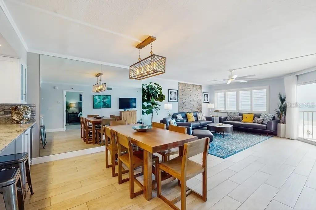AMPLE GREAT ROOM AREA WITH STUNNING BEACH VIEWS, NATURAL STONE WOOD-BURNING FIREPLACE,  AND OPEN KITCHEN COUNTER WITH ADDITIONAL WINE FRIDGE.