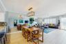 AMPLE GREAT ROOM AREA WITH STUNNING BEACH VIEWS, NATURAL STONE WOOD-BURNING FIREPLACE,  AND OPEN KITCHEN COUNTER WITH ADDITIONAL WINE FRIDGE.