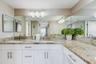 EN-SUITE BATHROOM WITH SEPARATE DRESSING AREA, DOUBLE SINKS, AND LARGE WALK-IN CLOSET WITH BUILT- IN WARDROBE ORGANIZERS COMPLETES THE SPACIOUS PRIMAR
