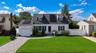 White-sided residence with a dark shingle roof featuring multiple solar panels