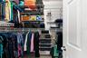 A large walk-in closet with built-in organization provides plenty of room to keep clothing, shoes, and accessories neatly arranged.